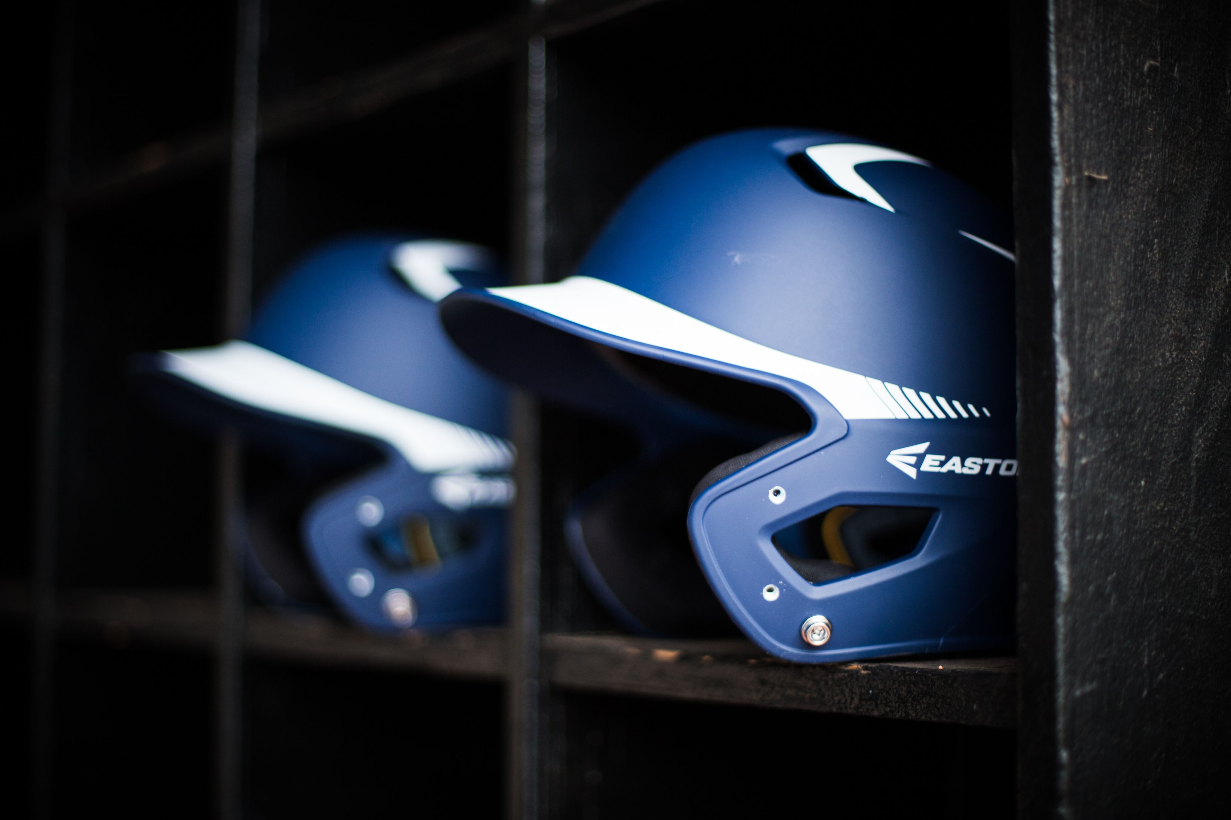 Two blue Easton-branded batting helmets with white graphics on the brim